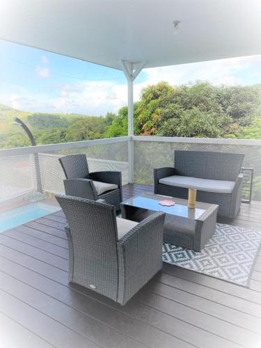 a patio with chairs and a table on a deck at Le domaine de Périolat in Le François