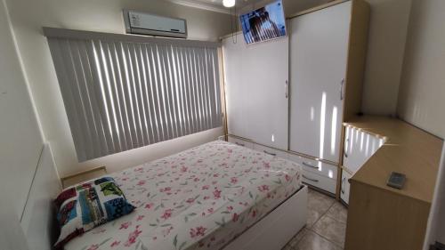 una piccola camera da letto con un letto fiorito di Apartamento na Praia do Morro -160 metros da praia -Ar condicionado e internet -Perto de tudo a Guarapari