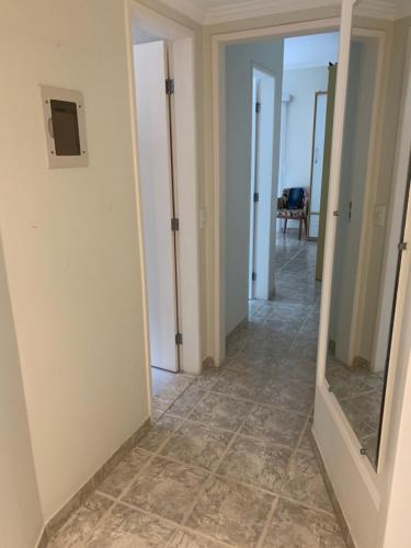 a hallway with a mirror and a tile floor at Apartamento na Praia do Morro -160 metros da praia -Ar condicionado e internet -Perto de tudo in Guarapari