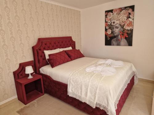 a bedroom with a bed with a red headboard at Sobe i apartmani Tena in Velika Gorica