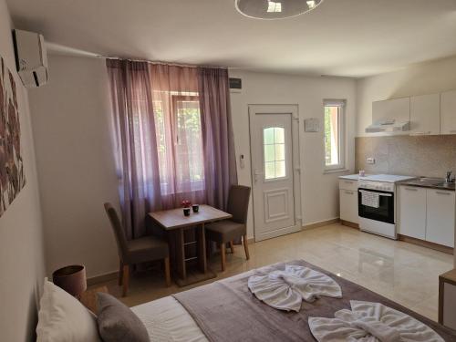 Cet appartement comprend une chambre avec un lit et une table ainsi qu'une cuisine. dans l'établissement Sobe i apartmani Tena, à Velika Gorica