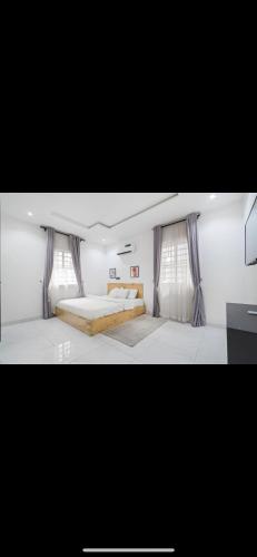 a bedroom with a large bed and curtains at Kaf lag apartment in Lekki