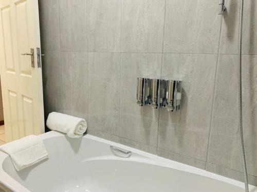 ein Badezimmer mit einem weißen Waschbecken und einer Dusche in der Unterkunft Mmaset Houses bed and breakfast in Gaborone