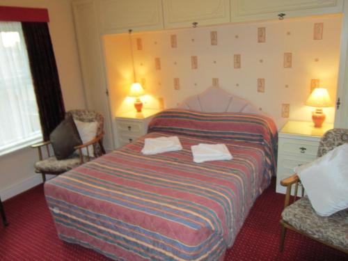 ブラックプールにあるSussex Hotelのベッド1台と椅子2脚が備わるホテルルームです。