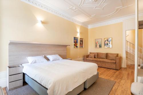 a bedroom with a large bed and a couch at Downtown Grand Houses in Porto