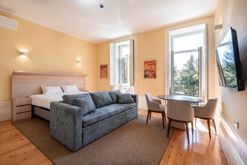 a living room with a couch and a bed and a table at Downtown Grand Houses in Porto