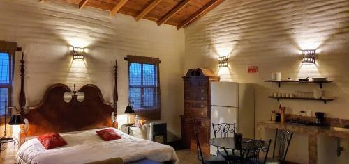 a bedroom with a large bed and a refrigerator at Echological Hotel, Restaurante & Spa in Lagos de Moreno