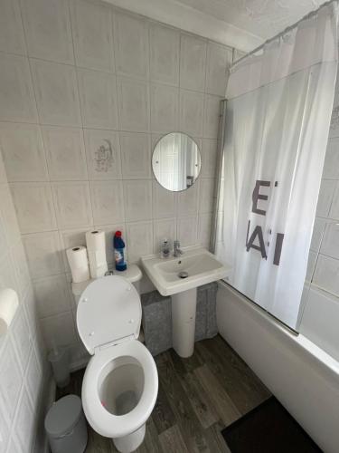 a white bathroom with a toilet and a sink at Holiday Home Cardiff City Sleeps 7 in Cardiff