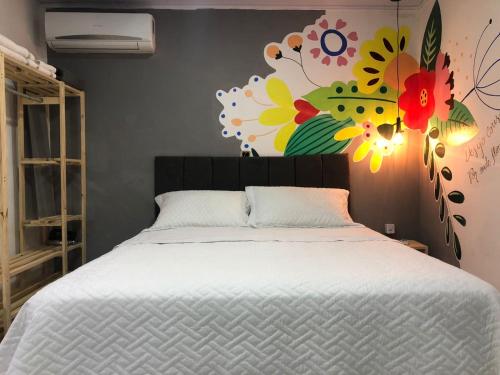 庫亞巴的住宿－Top Coliving I，卧室配有一张挂有花卉画的床铺。