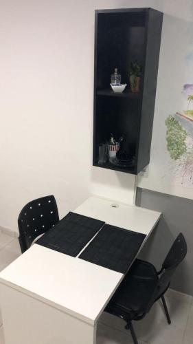 a white table with two chairs in a room at Top Coliving I in Cuiabá