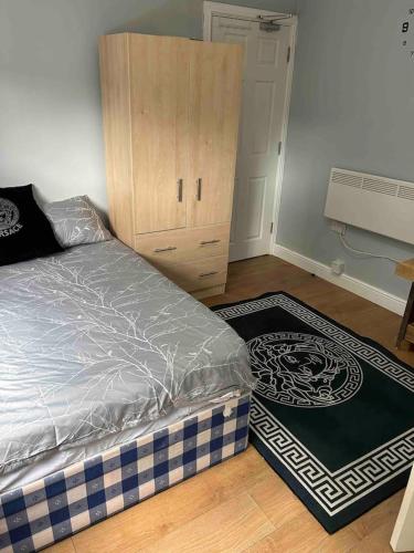 um quarto com uma cama e um armário de madeira em Studio apartment em Londres