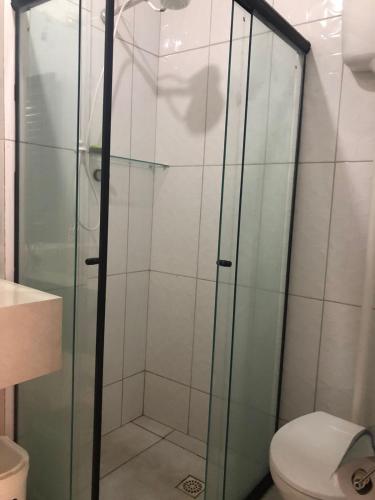 a glass shower in a bathroom with a toilet at Top Coliving I in Cuiabá