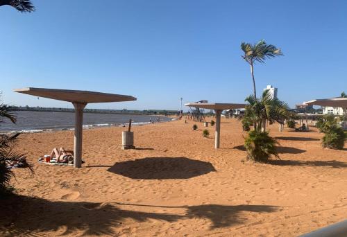 EDIFICIO REY NIÑO في بوساداس: شاطئ فيه مظلات وناس ممددة على الرمال