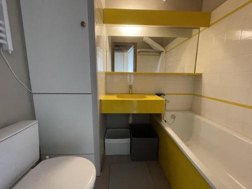 uma casa de banho com um lavatório amarelo e uma banheira em Appartement Huez, 1 pièce, 4 personnes - FR-1-405-225 em LʼHuez