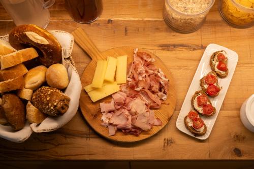 a wooden table topped with cheese and meats and bread at B&B Le Molinare Home Relax in Varda