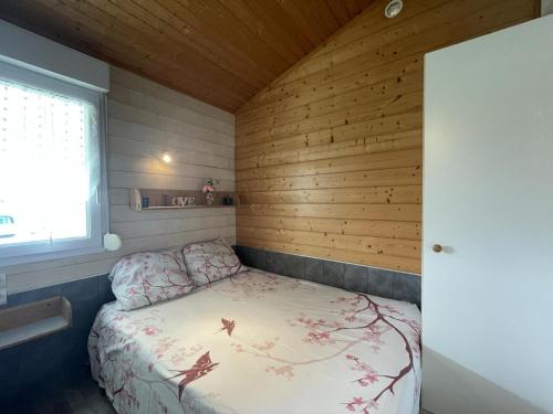 um pequeno quarto com uma cama num quarto com paredes de madeira em Gîte Pierrefitte-sur-Loire, 3 pièces, 4 personnes - FR-1-489-360 em Pierrefitte-sur-Loire
