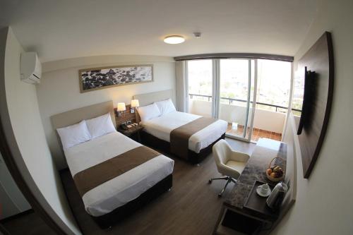 モケグアにあるDM Hoteles Moqueguaのベッド2台と窓が備わるホテルルームです。