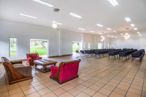 a large room with chairs and a room with tables and chairs at Hotel Xue Sabana in Cajicá