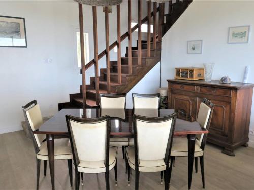 une salle à manger avec une table et des chaises et un escalier dans l'établissement Maison avec jardin clos à 800m de la plage à Trébeurden - FR-1-368-335, à Trébeurden