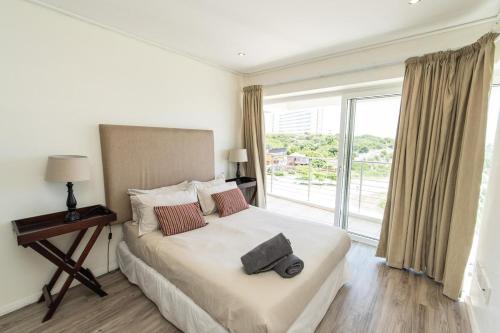 a bedroom with a bed and a large window at The Pearls 5th Floor Luxury Apartment in Port Elizabeth