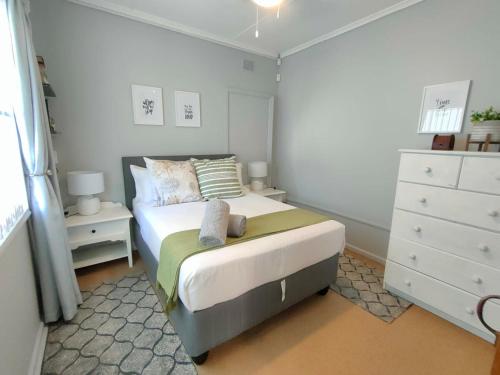a small bedroom with a bed and a dresser at Adorable Garden Cottage In The Heart Of Pe in Lorraine