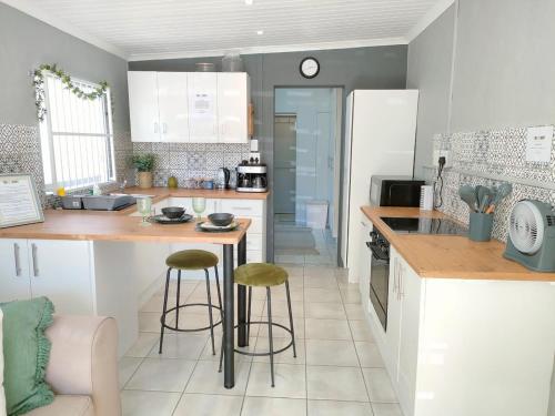 a kitchen with a counter and stools in it at Adorable Garden Cottage In The Heart Of Pe in Lorraine