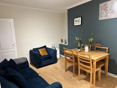 a living room with a table and a blue couch at Family or workers home - transport links & hiking in Porth