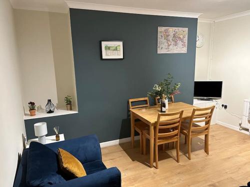 a living room with a table and a blue wall at Family or workers home - transport links & hiking in Porth