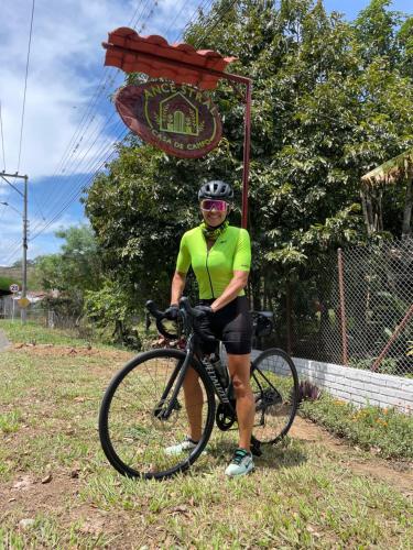 a man standing next to a bike in front of a sign at Ancestral Casa de Campo in Roldanillo