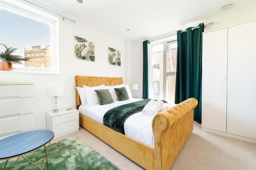 a bedroom with a bed and a table at Luxury Greenwich 2Bed 2Bath Apt - Sleep 6 Guest- 1 min from station - close to Greenwich Maritime- Playstation provided in London