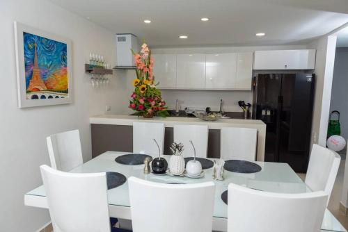 a dining room with a white table and white chairs at edificio astoria in Cali