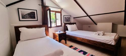 1 dormitorio con 2 camas y ventana en Hotel Gorica - UNESCO quarter en Berat