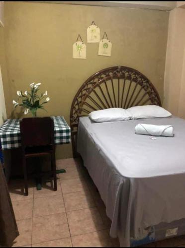 a bedroom with a bed and a chair and a table at Hotel El Castillo del Puerto in Puerto Barrios