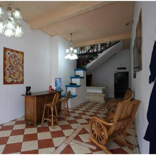 a living room with a table and chairs and a staircase at Hotel El Castillo del Puerto in Puerto Barrios