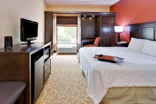 a hotel room with a bed and a flat screen tv at Hampton Inn Gettysburg in Gettysburg