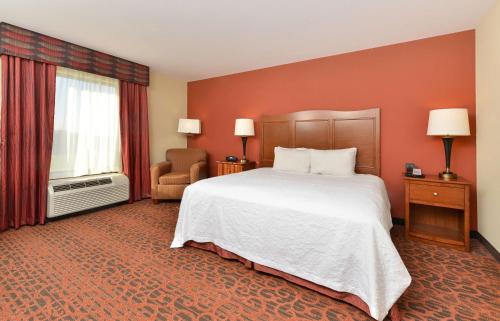 a hotel room with a large bed and a window at Hampton Inn Muscatine in Muscatine