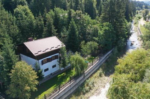an aerial view of a house next to a river at Cabana Gura Voronețului in Gura Humorului