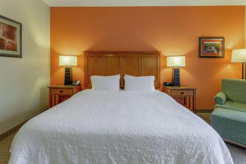 a bedroom with a large white bed and two chairs at Hampton Inn Okeechobee - Lake Okeechobee in Okeechobee