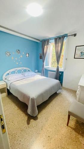 a blue bedroom with a bed and a window at Domi B & B in Macerata
