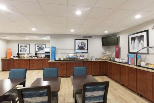 a restaurant with tables and chairs and a counter at Hampton Inn Saint Augustine Beach in Saint Augustine Beach