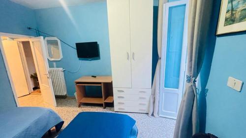a blue room with a bedroom with a bed and a desk at Domi B & B in Macerata