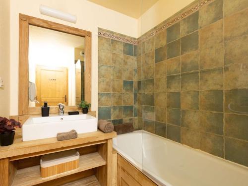 a bathroom with a sink and a tub and a mirror at Appartement Saint-Lary-Soulan, 4 pièces, 10 personnes - FR-1-296-394 in Saint-Lary-Soulan