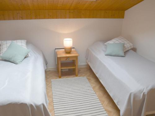 une chambre avec deux lits et une table avec une lampe dans l'établissement Appartement lumineux, 6 personnes avec balcon, parking, WiFi à 900m du centre de Châtel - FR-1-198-233, à Châtel