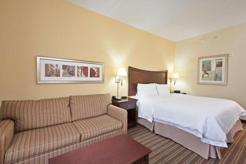 um quarto de hotel com uma cama e um sofá em Hampton Inn Gainesville-Haymarket em Gainesville