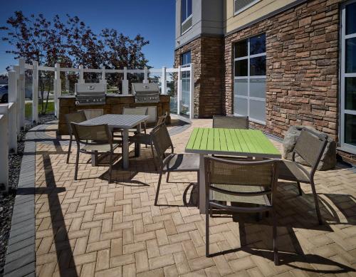 a patio with tables and chairs in front of a building at Homewood Suites Calgary Airport in Calgary