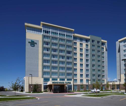 a large white building with a car parked in front of it at Homewood Suites Calgary Airport in Calgary