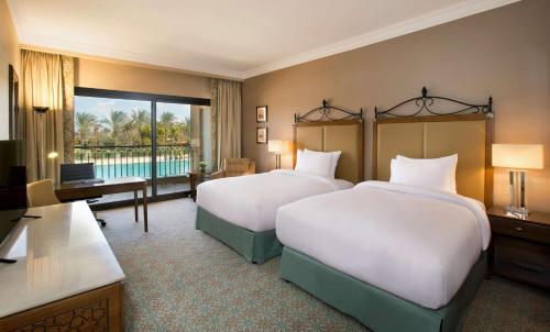 pokój hotelowy z 2 łóżkami i telewizorem w obiekcie Hilton Alexandria King's Ranch Hotel w Aleksandrii