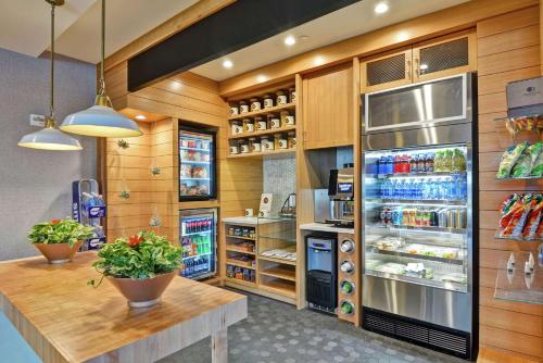 a kitchen with a refrigerator and a counter with drinks at DoubleTree by Hilton Hotel Baton Rouge in Baton Rouge