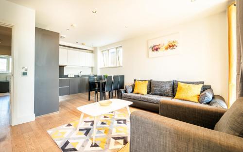 a living room with a couch and a table at Luxury Greenwich 2Bed 2Bath Apt - Sleep 6 Guest- 1 min from station - close to Greenwich Maritime- Playstation provided in London