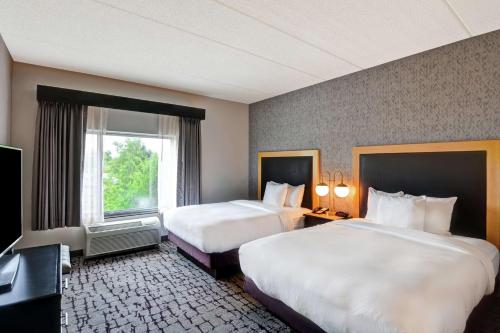 a hotel room with two beds and a window at DoubleTree by Hilton Baton Rouge in Baton Rouge